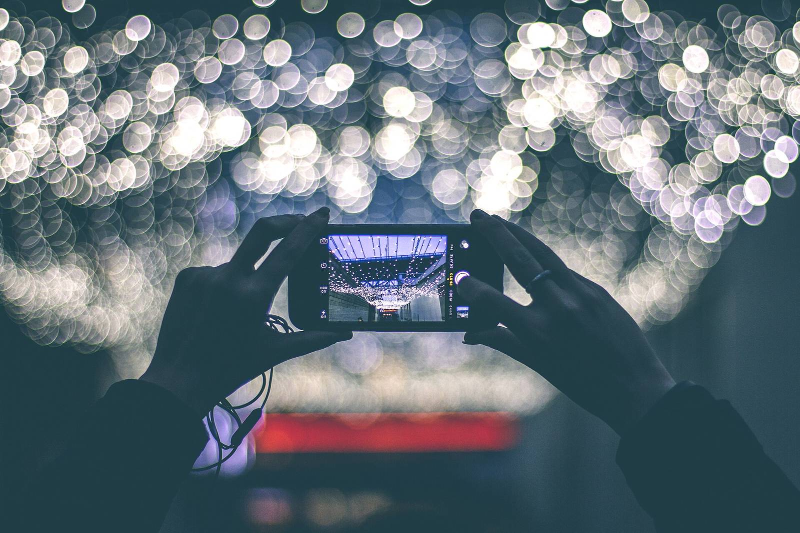 Hands holding a smartphone against blurred city lights