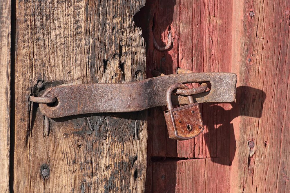 Rusty padlock on a wooden door